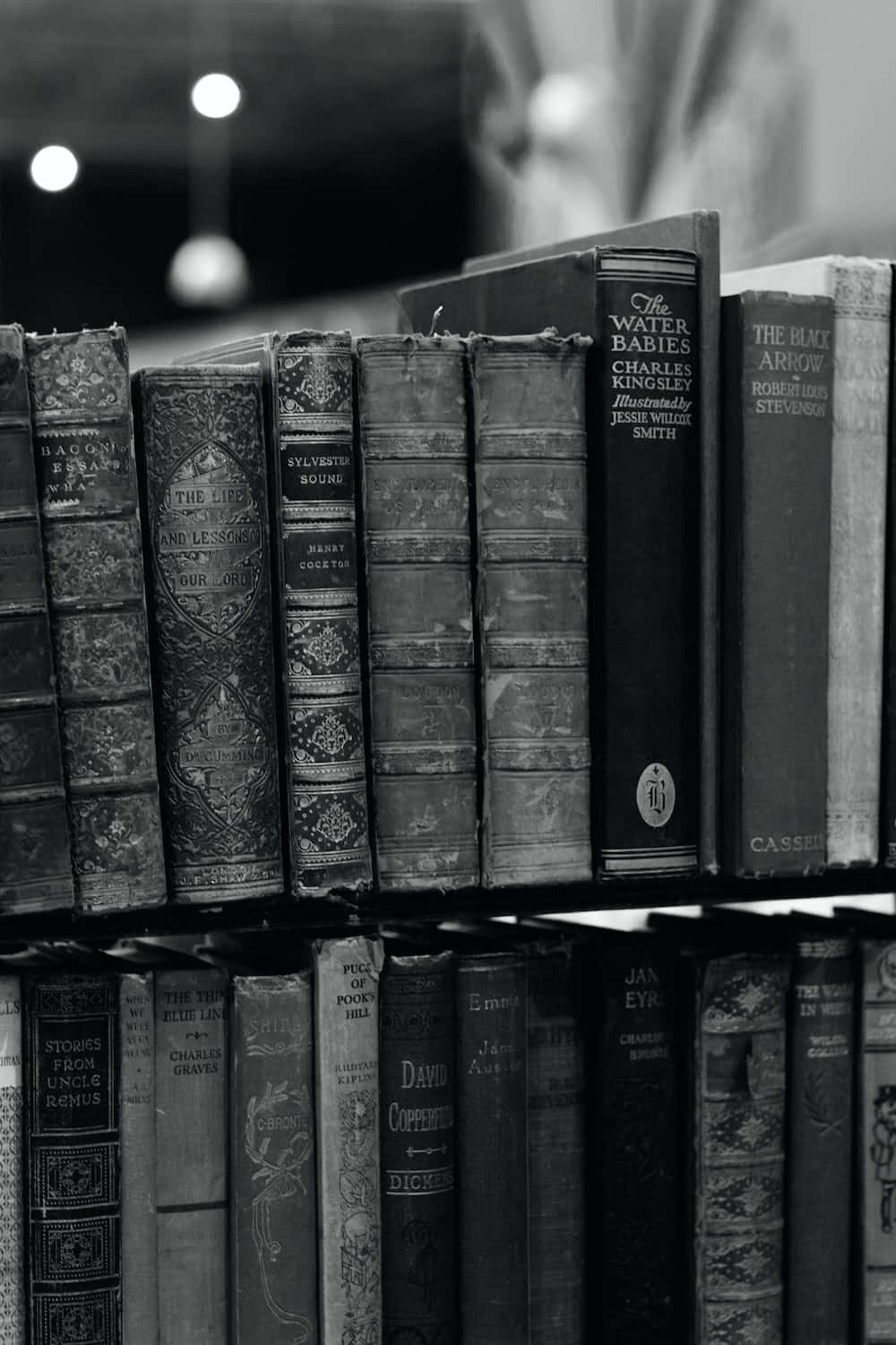 سیاہ اور سفید تصویر کتابوں کی ایک شیلف پر وال پیپر