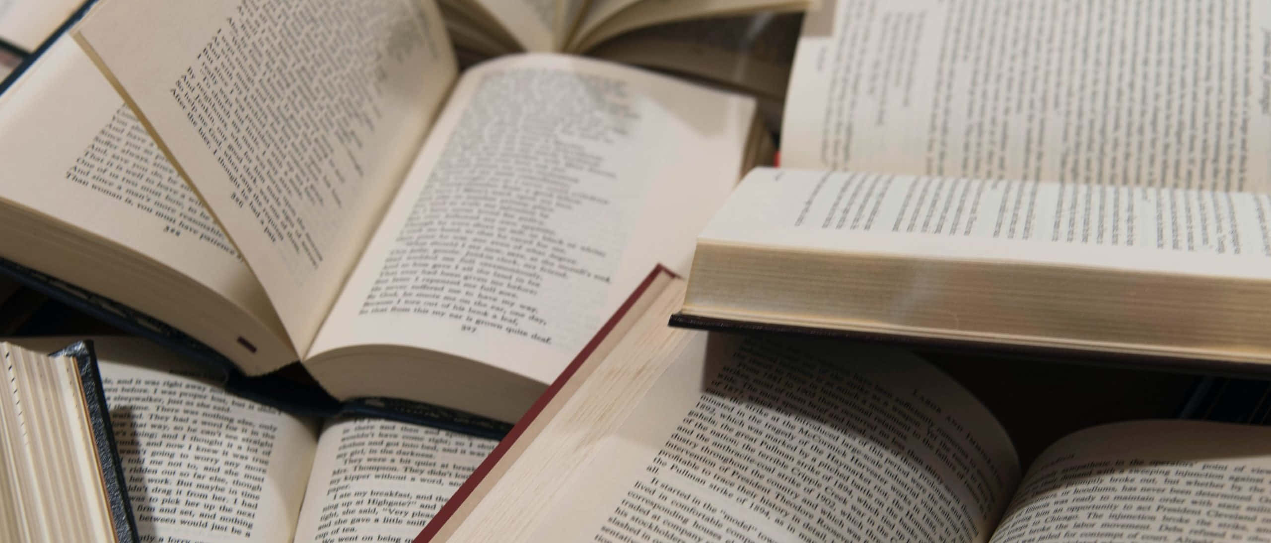 میز پر کتابوں کا ڈھیر وال پیپر